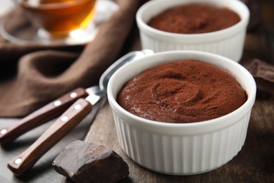 Delicious fresh fondant and chocolate on wooden board, closeup