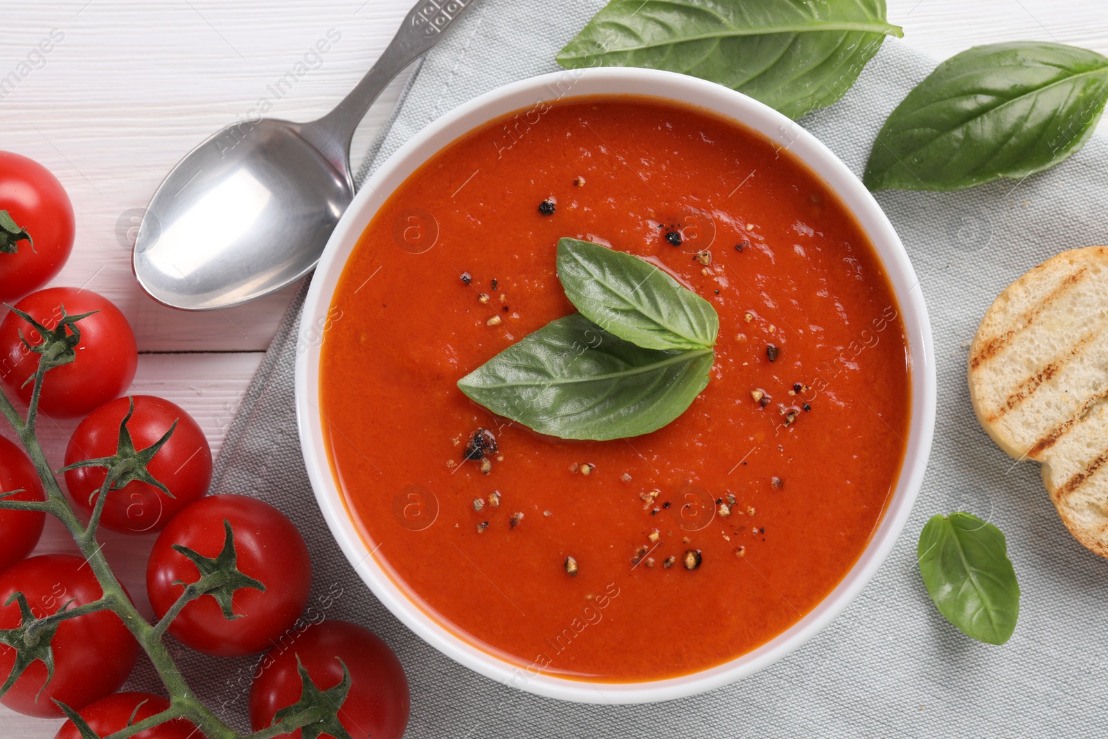 Photo of Flat lay composition with delicious tomato cream soup in bowl on white wooden table