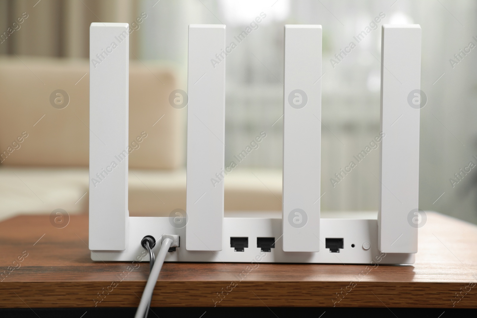 Photo of New modern Wi-Fi router on wooden table indoors