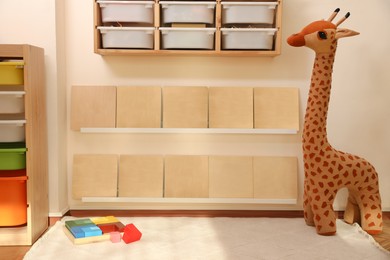 Montessori room interior with shelving unit and different toys