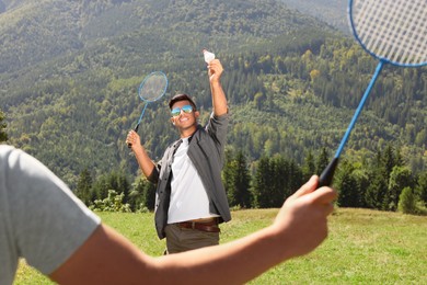 Photo of Friends playing badminton in mountains on sunny day
