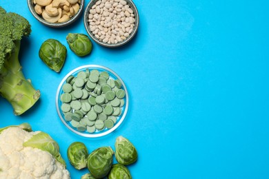 Photo of Many prebiotic pills and food on light blue background, flat lay. Space for text