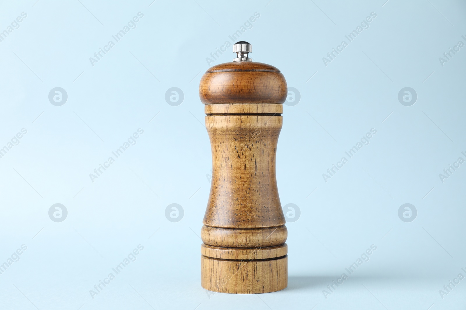 Photo of One wooden shaker on light background, closeup