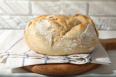 Photo of Freshly baked sourdough bread on white table