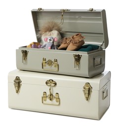 Photo of Stylish storage trunks with child's shoes and toys on white background. Interior elements