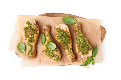 Delicious fried chicken drumsticks with pesto sauce and basil isolated on white, top view