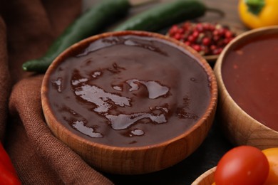 Photo of Homemade marinade in bowl on wooden table, closeup