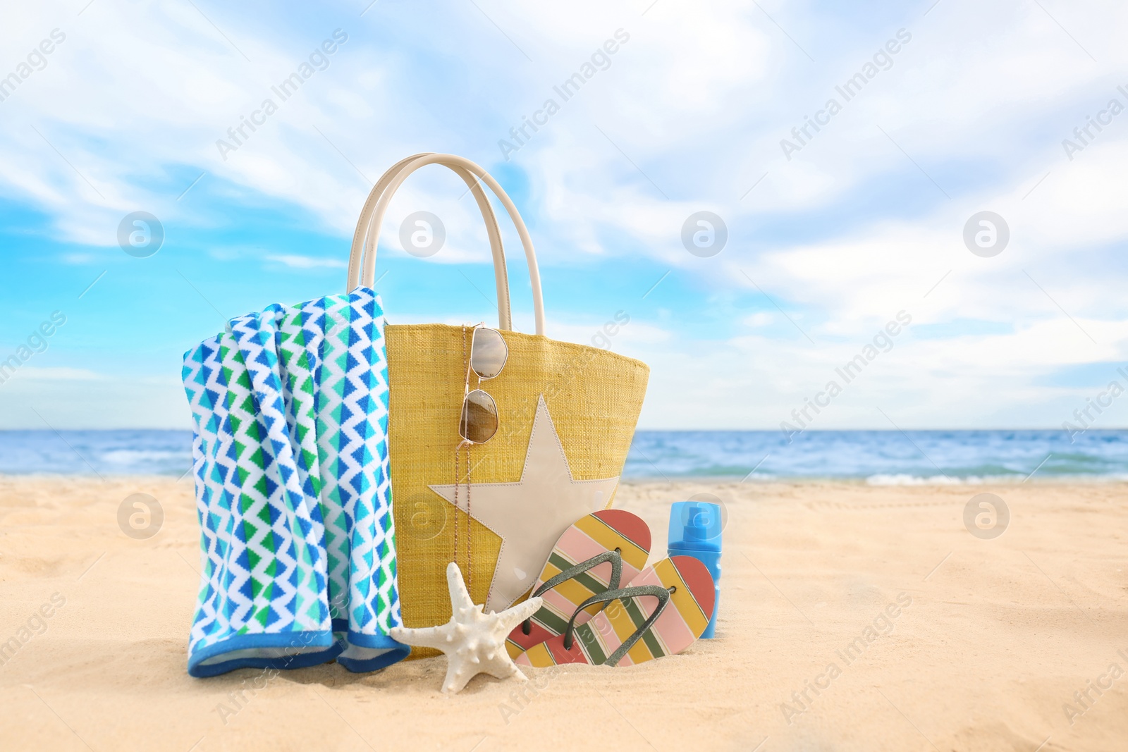 Photo of Different stylish beach objects and starfish on sand near sea