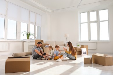 Photo of Happy family playing on floor in new apartment. Moving day