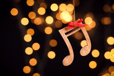 Photo of Wooden notes against blurred lights, space for text. Christmas music