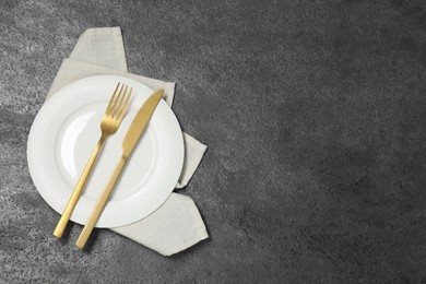 Stylish setting with elegant cutlery on grey table, top view. Space for text