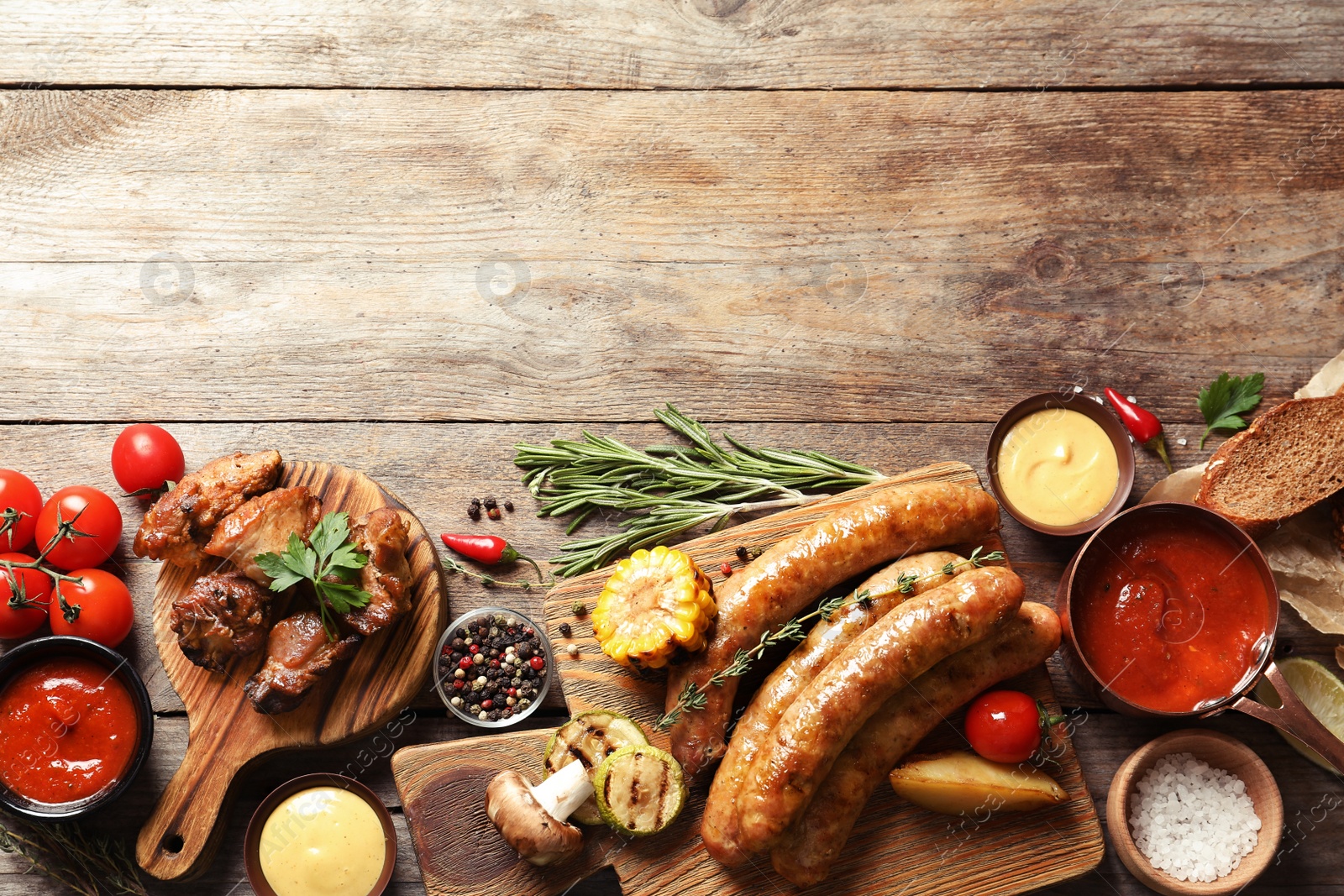 Photo of Flat lay composition with delicious barbecued meat and vegetables on wooden background. Space for text