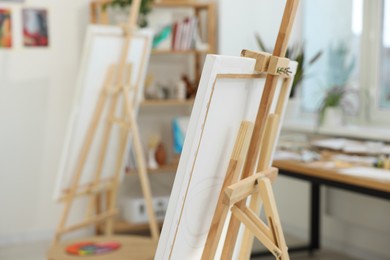 Photo of Wooden easel with canvas in artist's studio. Creative hobby