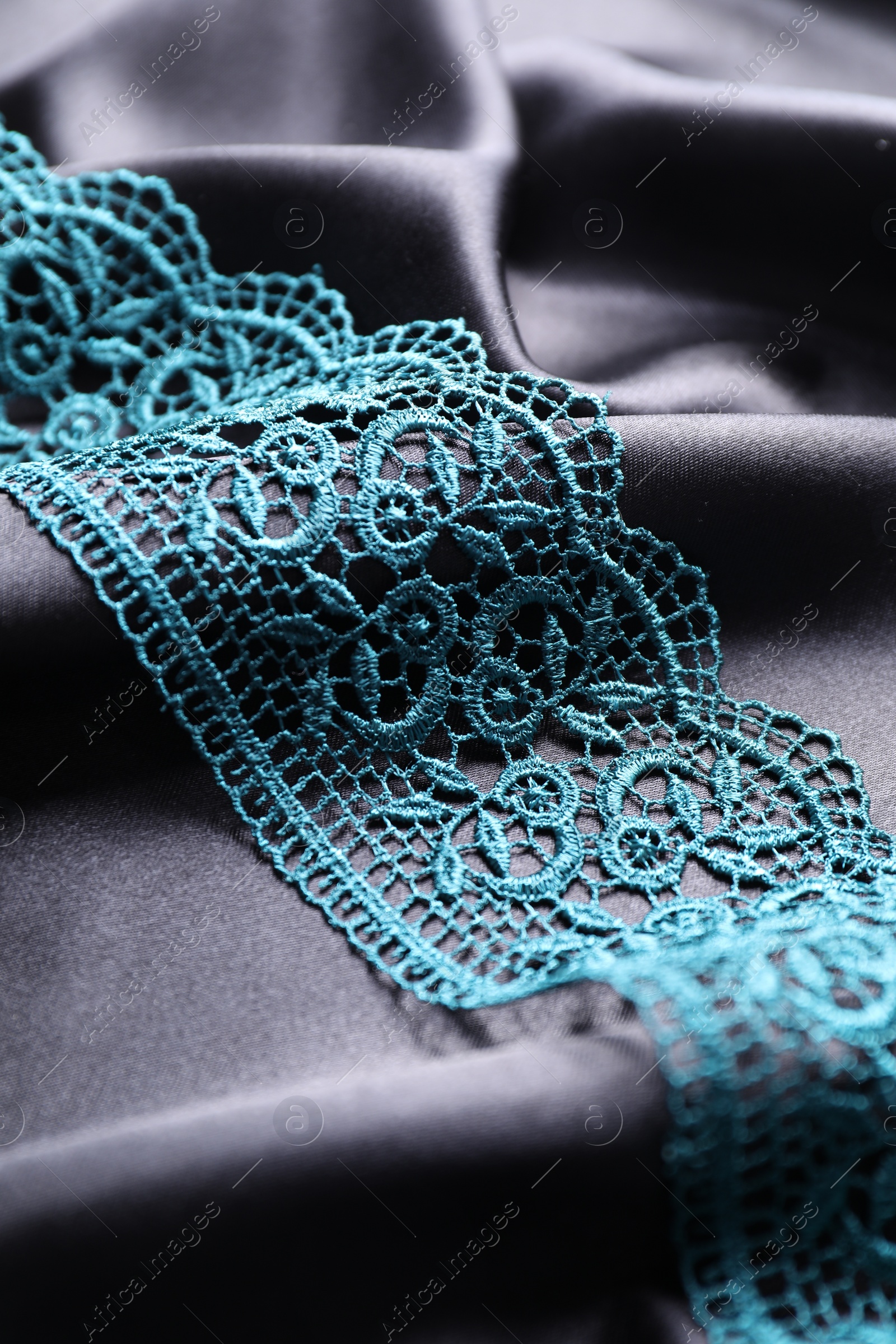 Photo of Beautiful green lace on black fabric, closeup