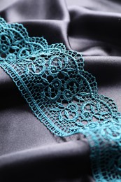 Photo of Beautiful green lace on black fabric, closeup