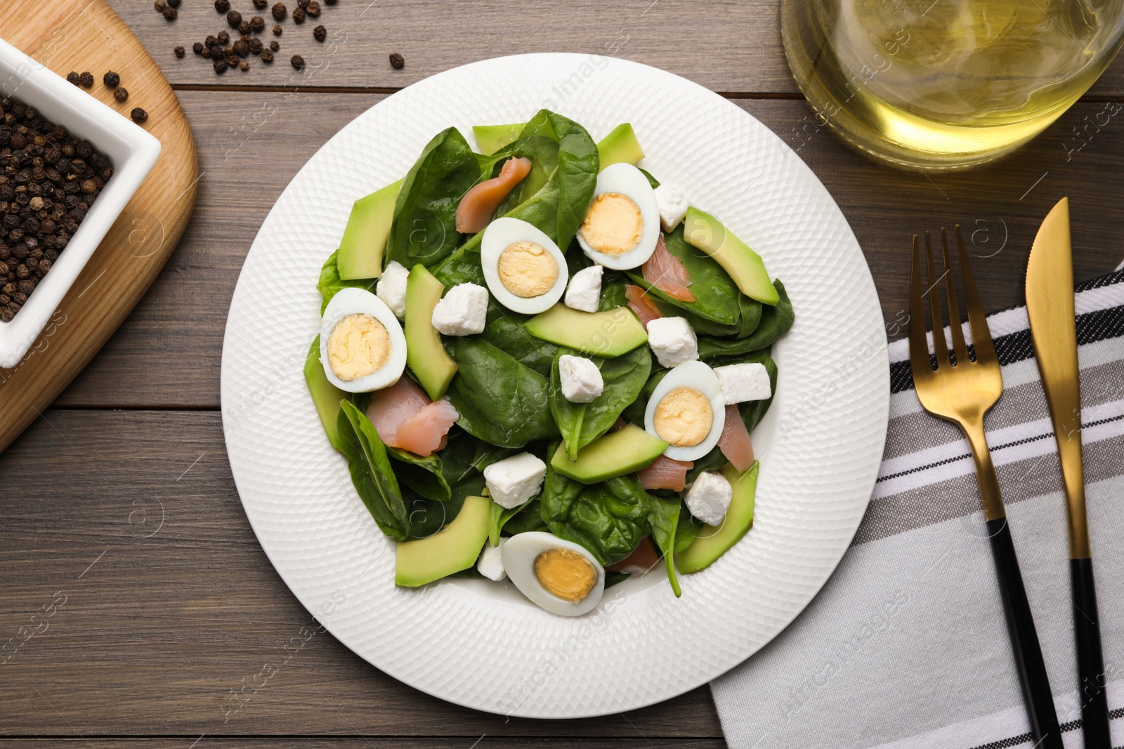 Photo of Delicious salad with boiled eggs, feta cheese and salmon served on wooden table, flat lay