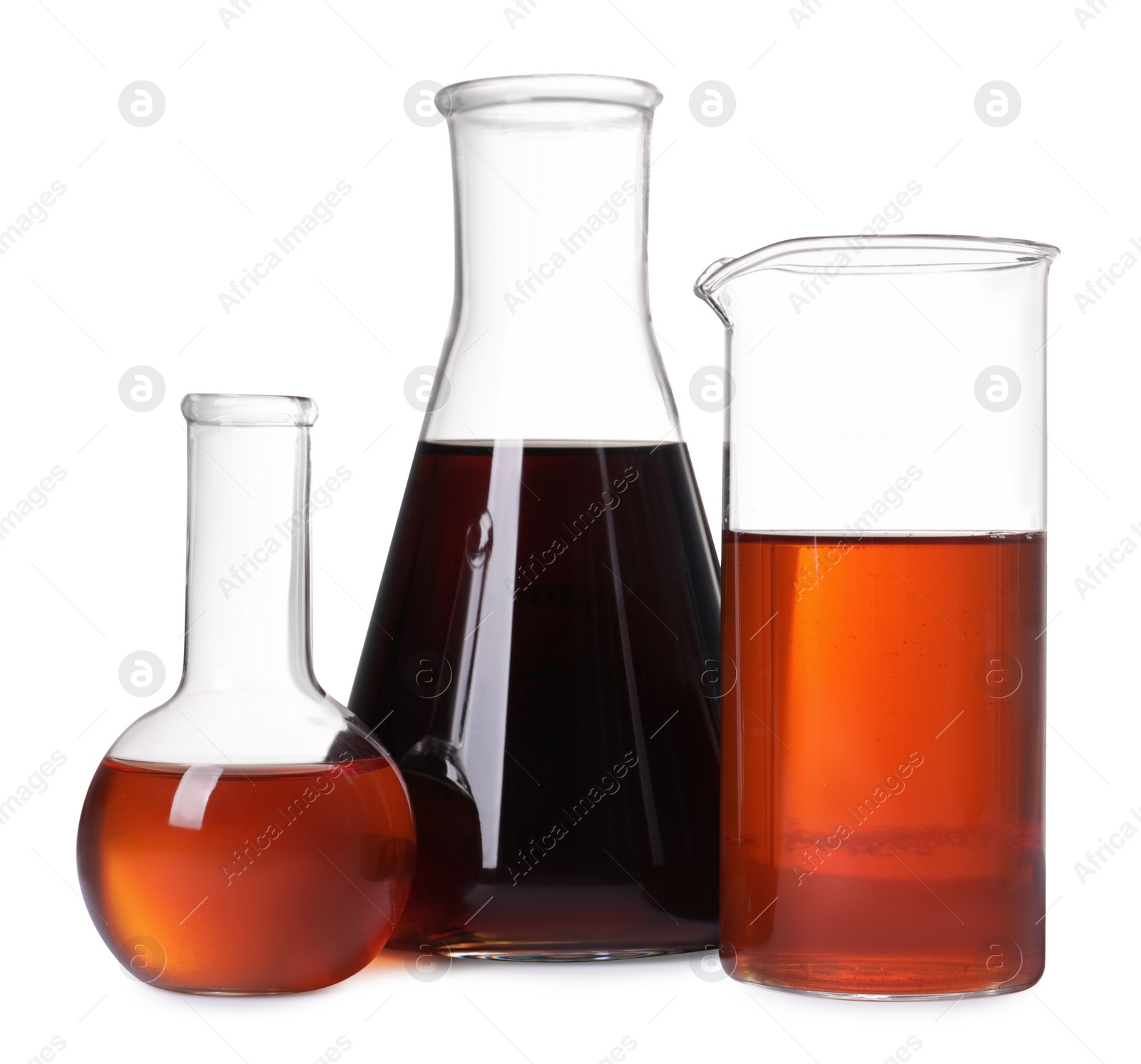 Photo of Different laboratory glassware with brown liquids on white background