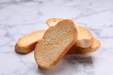 Photo of Hard chuck crackers on white marble table, closeup