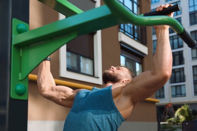 Photo of Man doing pull ups at outdoor gym