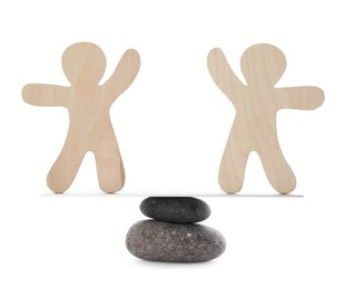 Photo of Balancing wooden human figures on stones against white background