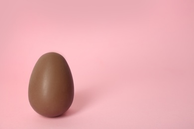 Photo of Sweet chocolate egg on pink background. Space for text