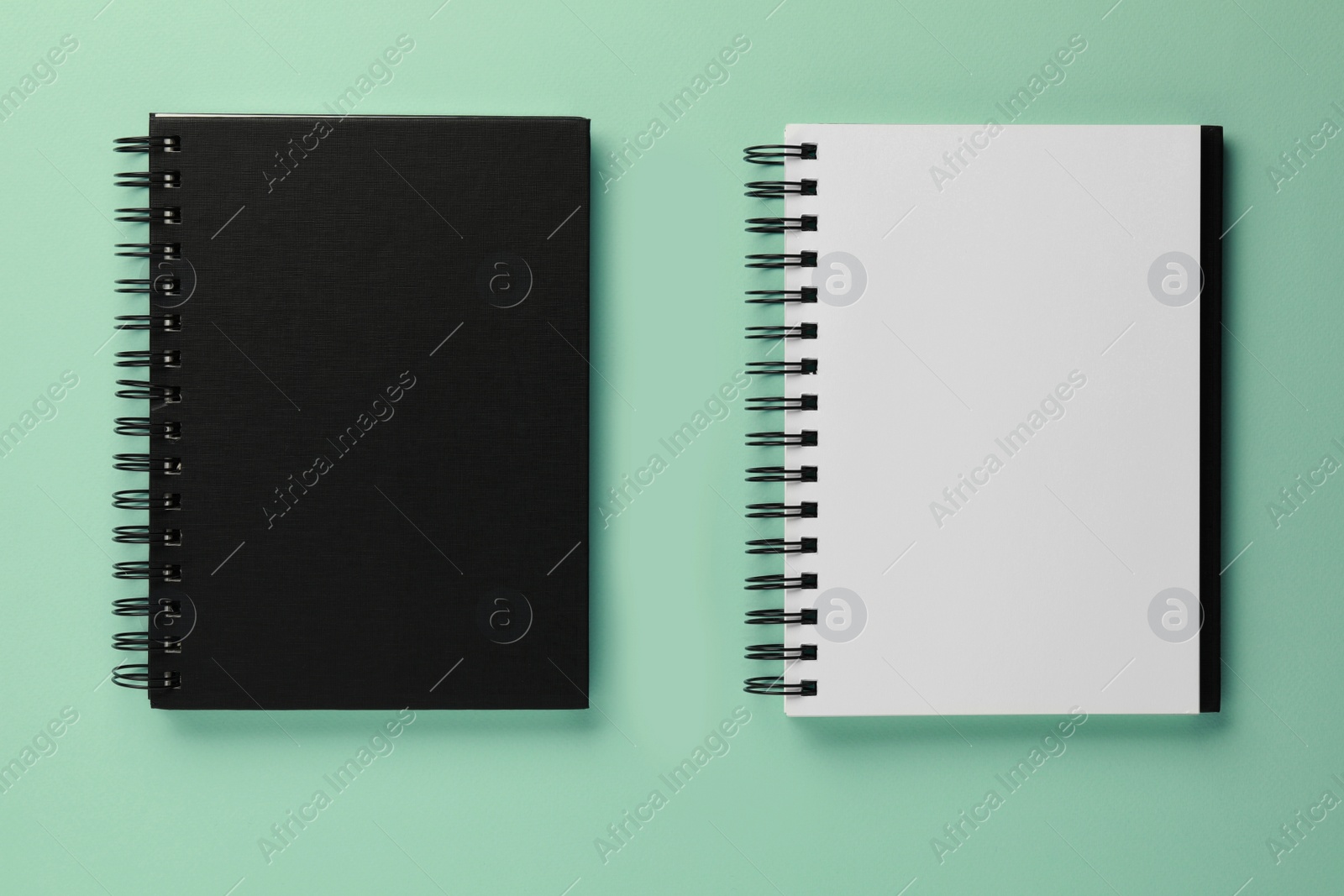 Photo of Two notebooks on turquoise background, flat lay