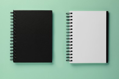 Photo of Two notebooks on turquoise background, flat lay