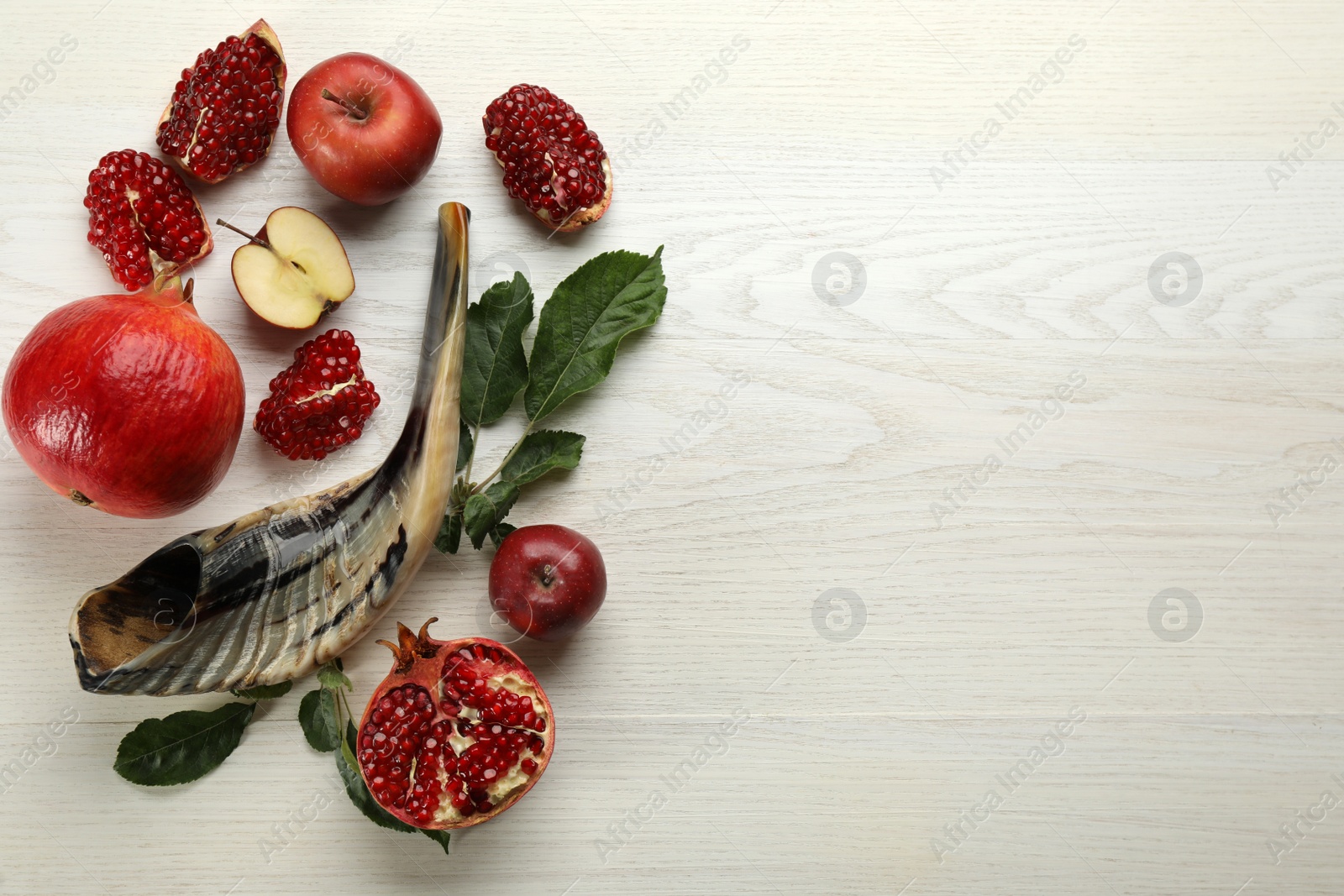 Photo of Flat lay composition with Rosh Hashanah holiday attributes on white wooden table. Space for text