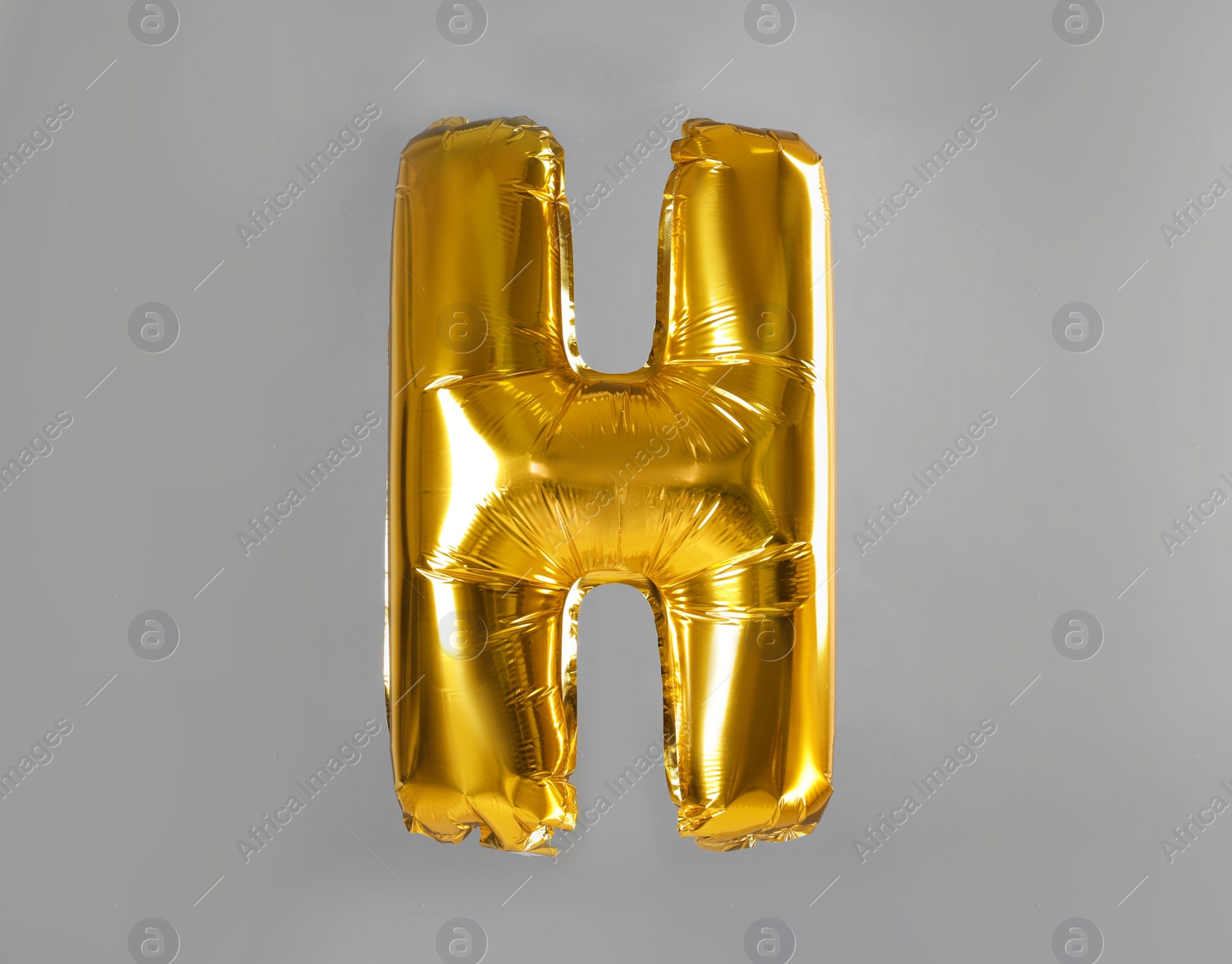 Photo of Golden letter H balloon on grey background