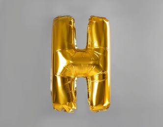 Photo of Golden letter H balloon on grey background