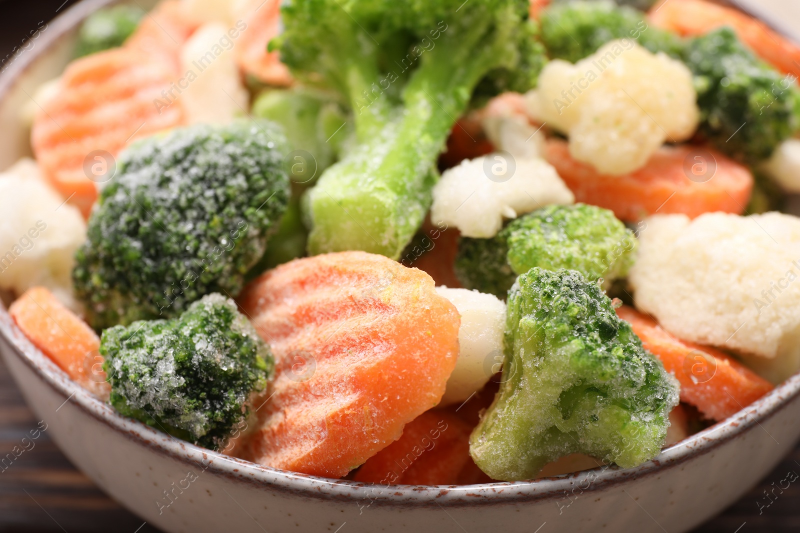 Photo of Mix of different frozen vegetables in bowl on table, closeup