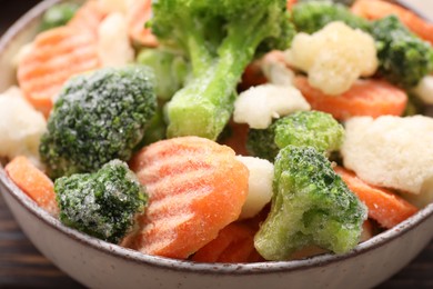 Mix of different frozen vegetables in bowl on table, closeup