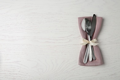 Photo of Cutlery set for festive table on white wooden background, top view. Space for text