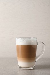 Hot coffee with milk in glass cup on light table