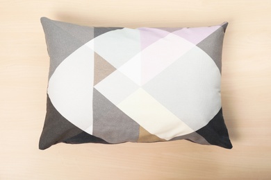 Photo of Soft decorative pillow on wooden background, top view