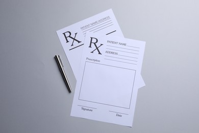 Photo of Medical prescription forms and pen on light grey background, flat lay