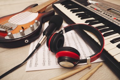 Different musical instruments, headphones and microphone on wooden background, closeup