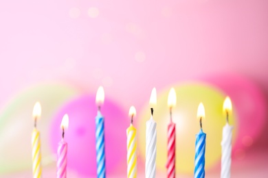 Photo of Burning birthday cake candles on color background. Space for text