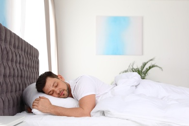 Photo of Handsome man sleeping on pillow at home. Bedtime