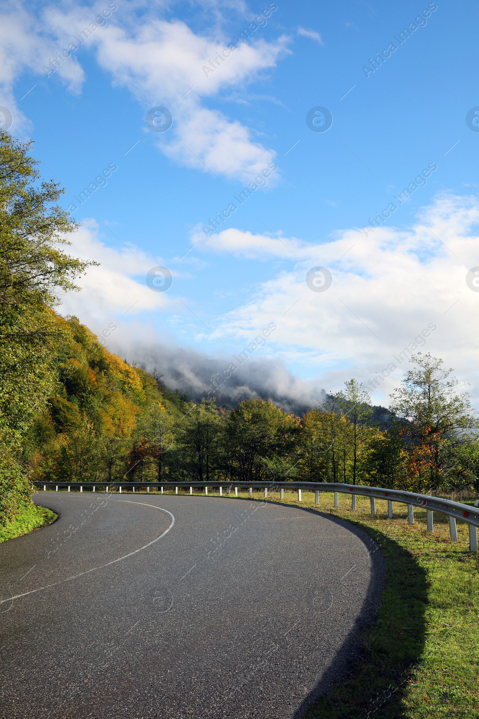 Photo of Picturesque view of empty road near trees in mountains