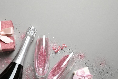 Photo of Flat lay composition with bottle of champagne for celebration on grey background. Space for text