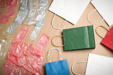 Photo of Flat lay composition with plastic and paper bags on beige background. Recycling concept