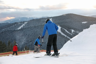 Photo of People skiing on snowy hill in mountains. Winter vacation