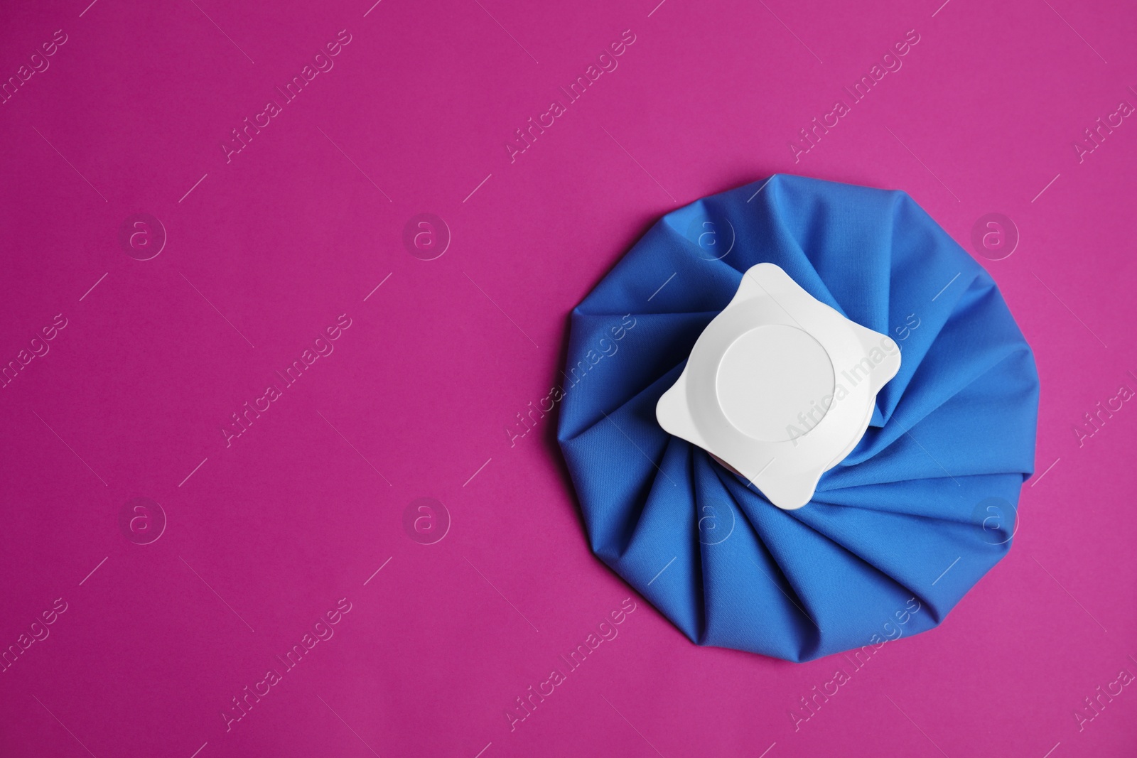 Photo of Ice pack on purple background, top view. Space for text