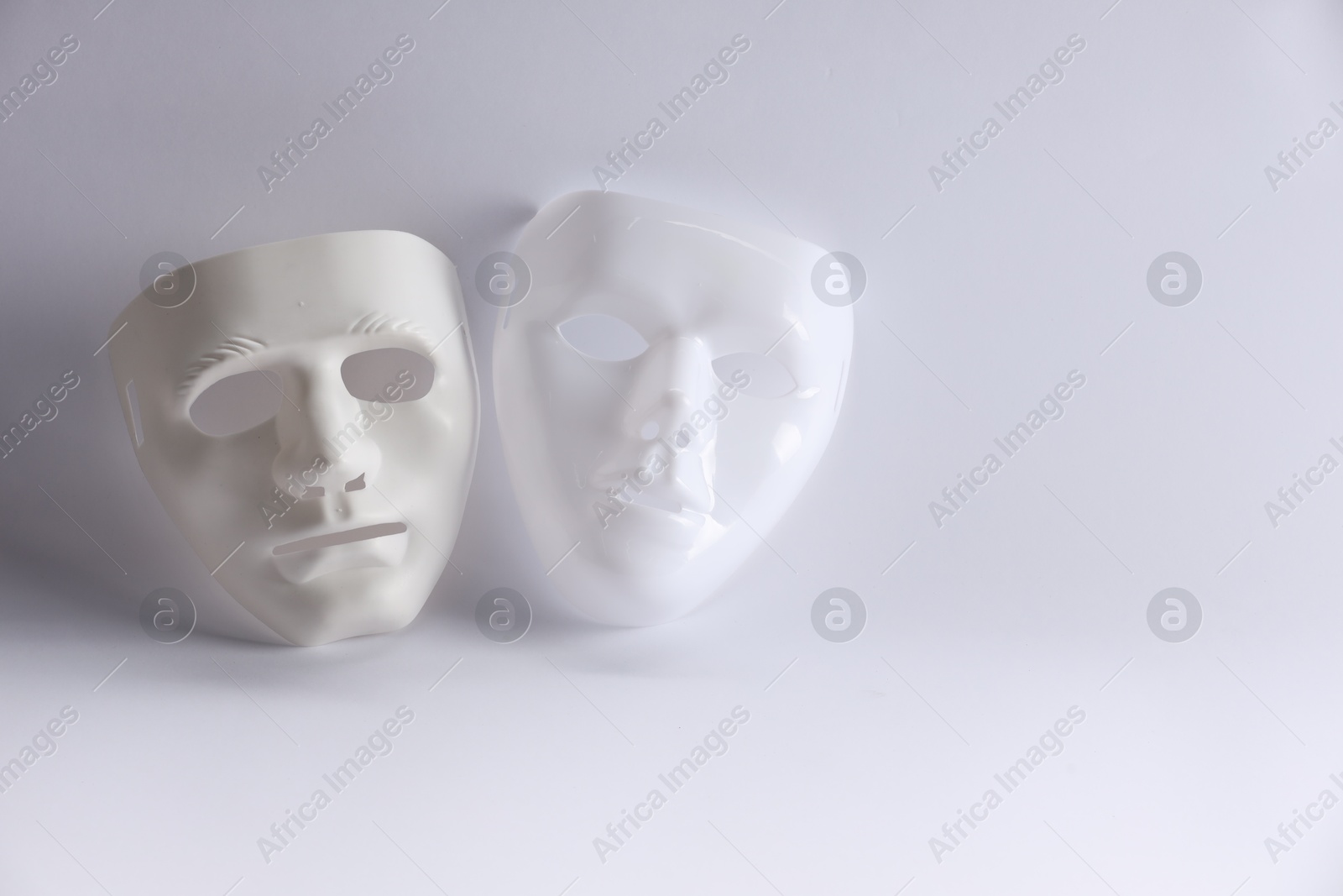 Photo of Plastic face masks on white background, space for text. Theatrical performance