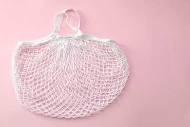 Photo of White string bag on pink background, top view. Space for text