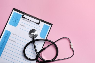 Photo of Clipboard with medical prescription form and stethoscope on pink background, flat lay. Space for text