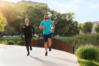 Photo of Healthy lifestyle. Happy couple running outdoors, space for text