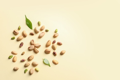 Composition with organic pistachio nuts on color background, flat lay. Space for text