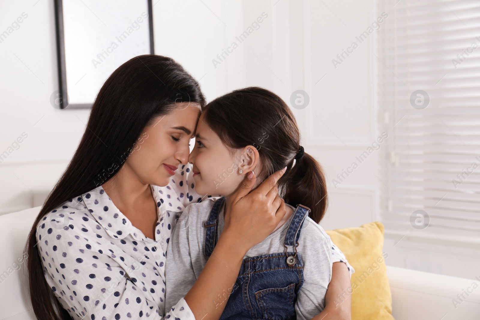 Photo of Happy mother and daughter touching foreheads at home. Single parenting